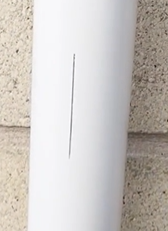 A broken gutter with a long crack in it. 